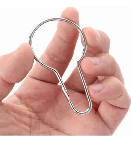 Mão segurando um gancho argola prateado, foto do anúncio do produto no Mercado Livre