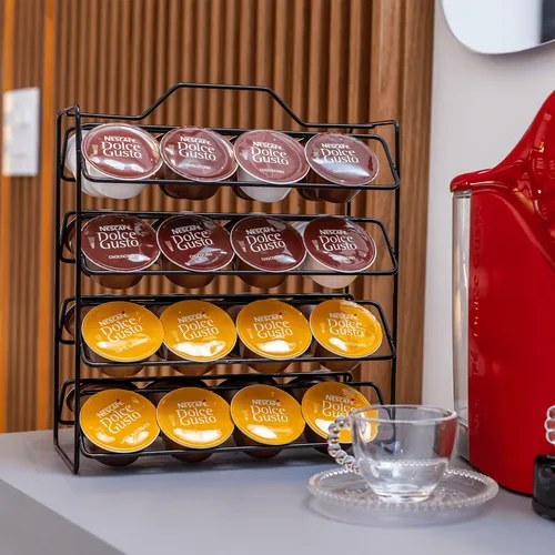Suporte preto de metal com cápsulas Dolce Gusto ao lado de cafeteira vermelha, foto do anúncio do produto no Mercado Livre