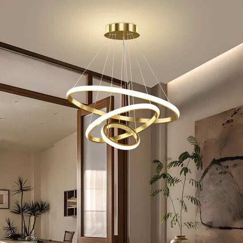 Lustre de três arcos de LED dourados acesos em sala, foto do anúncio do produto no Mercado Livre
