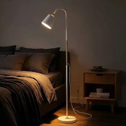 Luminária de chão branca com haste fina e cúpula, acesa ao lado da cama, foto do anúncio do produto no Mercado Livre