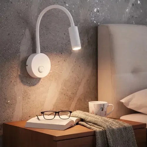 Arandela branca com haste flexível acesa sobre mesa de cabeceira com livro e óculos, foto do anúncio do produto no Mercado Livre